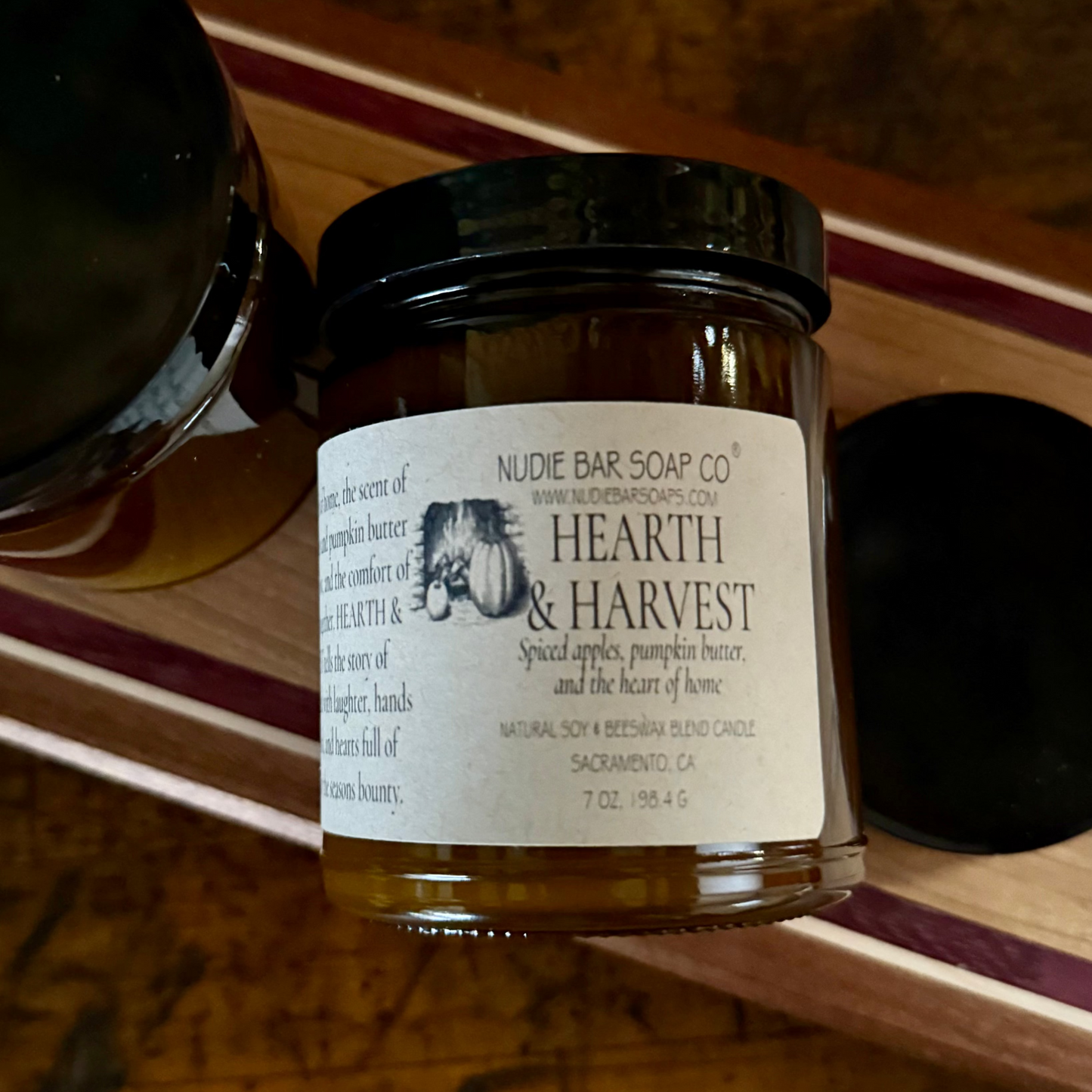 Jar of Nudie Bar Soap Co. 'Hearth & Harvest' soap on a wooden surface