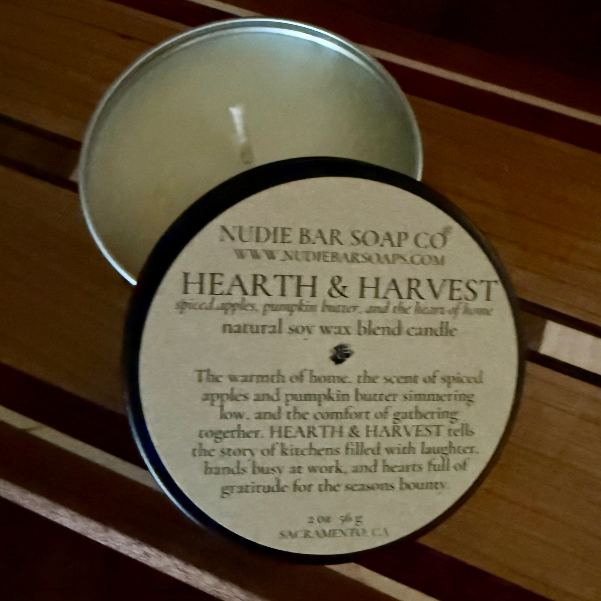 Nudie Bar Soap Co. 'Hearth & Harvest' candle on a wooden surface