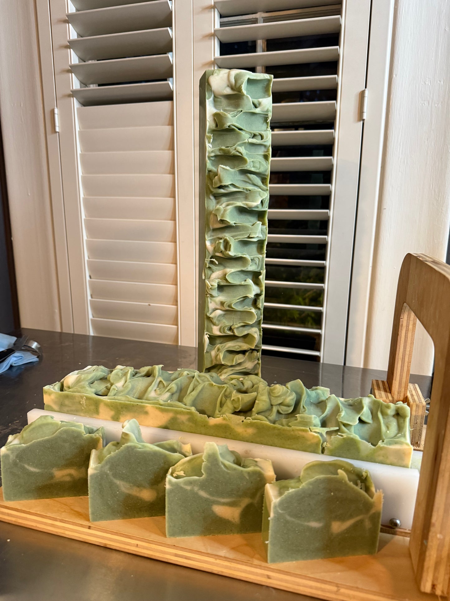 Green soap bars on a wooden tray with a window in the background