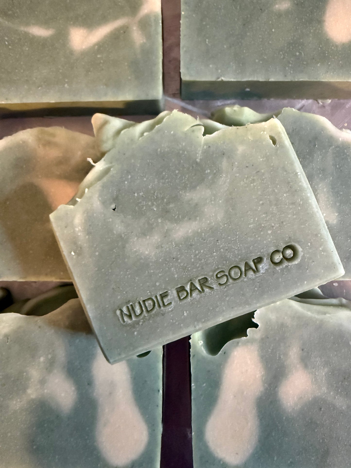 Bar of soap with 'Nudie Bar Soap Co' branding on a reflective surface